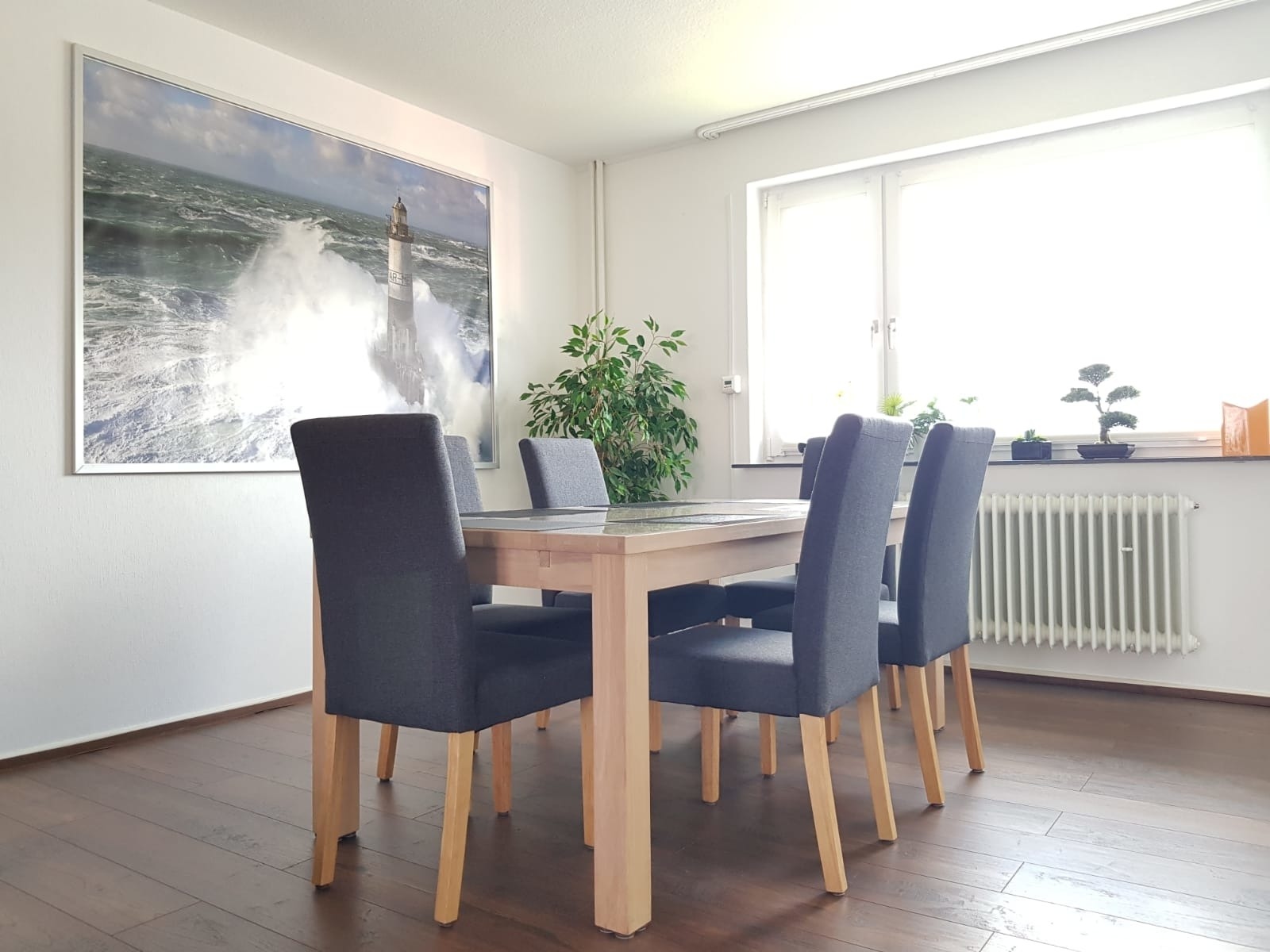 Esszimmer mit großem Holztisch und sechs Stühlen